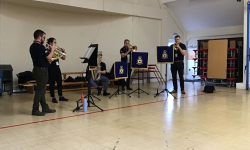 Five musicians playing brass instruments